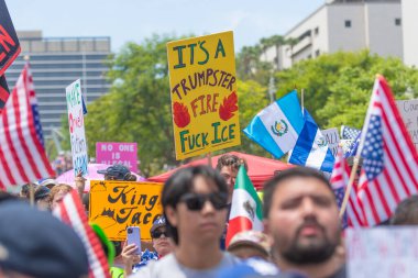 Los Angeles, Kaliforniya, ABD, 14 Temmuz 2025, Hükümetin politikalarını protesto eden ve demokrasi ve göçmen haklarını destekleyen protestocular ellerinde sloganlar tutuyorlar..