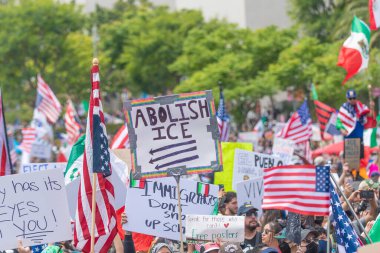 Los Angeles, Kaliforniya, ABD, 14 Temmuz 2025, Hükümetin politikalarını protesto eden ve demokrasi ve göçmen haklarını destekleyen protestocular ellerinde sloganlar tutuyorlar..
