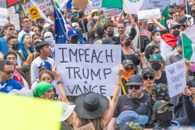 Los Angeles, Kaliforniya, ABD, 14 Temmuz 2025, Hükümetin politikalarını protesto eden ve demokrasi ve göçmen haklarını destekleyen protestocular ellerinde sloganlar tutuyorlar..