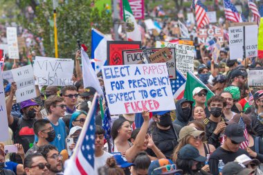 Los Angeles, Kaliforniya, ABD, 14 Temmuz 2025, Hükümetin politikalarını protesto eden ve demokrasi ve göçmen haklarını destekleyen protestocular ellerinde sloganlar tutuyorlar..