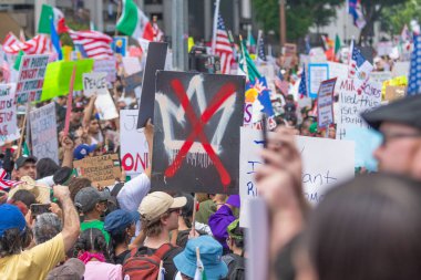 Los Angeles, Kaliforniya, ABD, 14 Temmuz 2025, Hükümetin politikalarını protesto eden ve demokrasi ve göçmen haklarını destekleyen protestocular ellerinde sloganlar tutuyorlar..