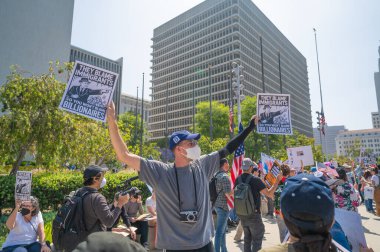 Los Angeles, Kaliforniya, ABD, 14 Temmuz 2025, Hükümetin politikalarını protesto eden ve demokrasi ve göçmen haklarını destekleyen protestocular ellerinde sloganlar tutuyorlar..