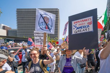 Los Angeles, Kaliforniya, ABD, 14 Temmuz 2025, Hükümetin politikalarını protesto eden ve demokrasi ve göçmen haklarını destekleyen protestocular ellerinde sloganlar tutuyorlar..