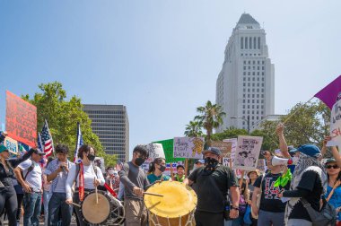 Los Angeles, Kaliforniya, ABD, 14 Temmuz 2025, Hükümetin politikalarını protesto eden ve demokrasi ve göçmen haklarını destekleyen protestocular ellerinde sloganlar tutuyorlar..