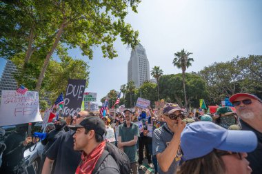 Los Angeles, Kaliforniya, ABD, 14 Temmuz 2025, Hükümetin politikalarını protesto eden ve demokrasi ve göçmen haklarını destekleyen protestocular ellerinde sloganlar tutuyorlar..