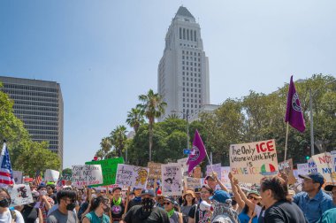 Los Angeles, Kaliforniya, ABD, 14 Temmuz 2025, Hükümetin politikalarını protesto eden ve demokrasi ve göçmen haklarını destekleyen protestocular ellerinde sloganlar tutuyorlar..