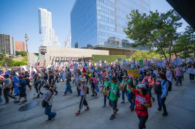 Los Angeles, Kaliforniya, ABD, 14 Temmuz 2025, Hükümetin politikalarını protesto eden ve demokrasi ve göçmen haklarını destekleyen protestocular ellerinde sloganlar tutuyorlar..