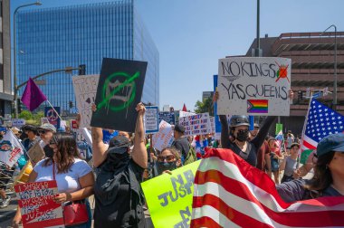 Los Angeles, Kaliforniya, ABD, 14 Temmuz 2025, Hükümetin politikalarını protesto eden ve demokrasi ve göçmen haklarını destekleyen protestocular ellerinde sloganlar tutuyorlar..