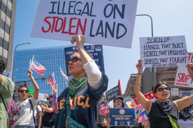 Los Angeles, Kaliforniya, ABD, 14 Temmuz 2025, Hükümetin politikalarını protesto eden ve demokrasi ve göçmen haklarını destekleyen protestocular ellerinde sloganlar tutuyorlar..
