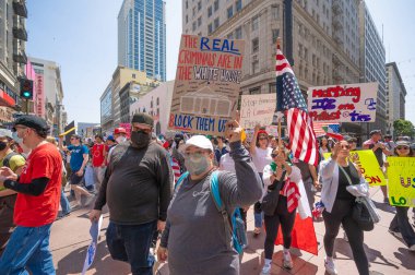 Los Angeles, Kaliforniya, ABD, 14 Temmuz 2025, Hükümetin politikalarını protesto eden ve demokrasi ve göçmen haklarını destekleyen protestocular ellerinde sloganlar tutuyorlar..