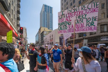 Los Angeles, Kaliforniya, ABD, 14 Temmuz 2025, Hükümetin politikalarını protesto eden ve demokrasi ve göçmen haklarını destekleyen protestocular ellerinde sloganlar tutuyorlar..
