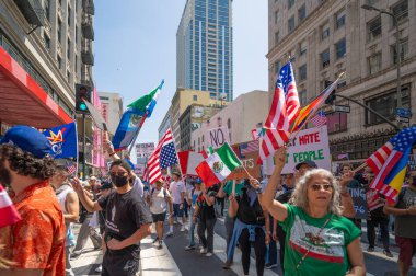 Los Angeles, Kaliforniya, ABD, 14 Temmuz 2025, Hükümetin politikalarını protesto eden ve demokrasi ve göçmen haklarını destekleyen protestocular ellerinde sloganlar tutuyorlar..