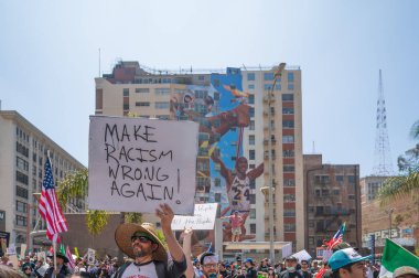Los Angeles, Kaliforniya, ABD, 14 Temmuz 2025, Hükümetin politikalarını protesto eden ve demokrasi ve göçmen haklarını destekleyen protestocular ellerinde sloganlar tutuyorlar..