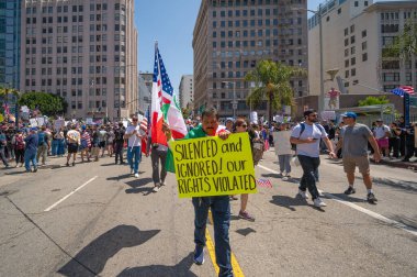 Los Angeles, Kaliforniya, ABD, 14 Temmuz 2025, Hükümetin politikalarını protesto eden ve demokrasi ve göçmen haklarını destekleyen protestocular ellerinde sloganlar tutuyorlar..