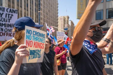 Los Angeles, Kaliforniya, ABD, 14 Temmuz 2025, Hükümetin politikalarını protesto eden ve demokrasi ve göçmen haklarını destekleyen protestocular ellerinde sloganlar tutuyorlar..
