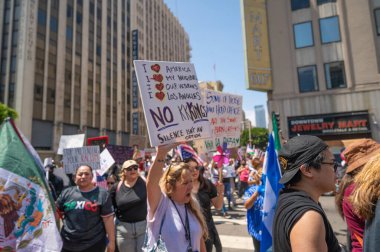 Los Angeles, Kaliforniya, ABD, 14 Temmuz 2025, Hükümetin politikalarını protesto eden ve demokrasi ve göçmen haklarını destekleyen protestocular ellerinde sloganlar tutuyorlar..