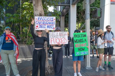 Los Angeles, Kaliforniya, ABD, 14 Temmuz 2025, Hükümetin politikalarını protesto eden ve demokrasi ve göçmen haklarını destekleyen protestocular ellerinde sloganlar tutuyorlar..