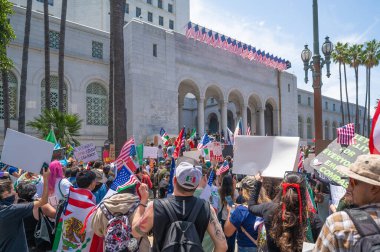 Los Angeles, Kaliforniya, ABD, 14 Temmuz 2025, Hükümetin politikalarını protesto eden ve demokrasi ve göçmen haklarını destekleyen protestocular ellerinde sloganlar tutuyorlar..