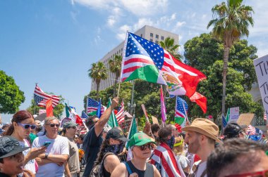 Los Angeles, Kaliforniya, ABD, 14 Temmuz 2025, Hükümetin politikalarını protesto eden ve demokrasi ve göçmen haklarını destekleyen protestocular ellerinde sloganlar tutuyorlar..
