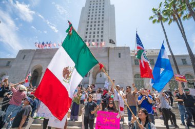 Los Angeles, Kaliforniya, ABD, 14 Temmuz 2025, Hükümetin politikalarını protesto eden ve demokrasi ve göçmen haklarını destekleyen protestocular ellerinde sloganlar tutuyorlar..