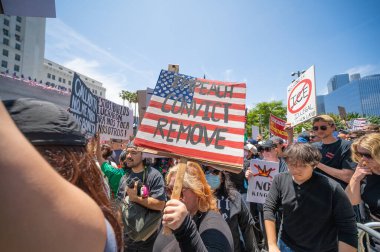 Los Angeles, Kaliforniya, ABD, 14 Temmuz 2025, Hükümetin politikalarını protesto eden ve demokrasi ve göçmen haklarını destekleyen protestocular ellerinde sloganlar tutuyorlar..