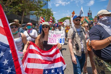 Los Angeles, Kaliforniya, ABD, 14 Temmuz 2025, Hükümetin politikalarını protesto eden ve demokrasi ve göçmen haklarını destekleyen protestocular ellerinde sloganlar tutuyorlar..