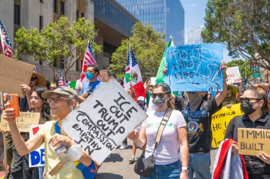Los Angeles, Kaliforniya, ABD, 14 Temmuz 2025, Hükümetin politikalarını protesto eden ve demokrasi ve göçmen haklarını destekleyen protestocular ellerinde sloganlar tutuyorlar..