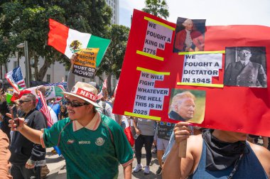 Los Angeles, Kaliforniya, ABD, 14 Temmuz 2025, Hükümetin politikalarını protesto eden ve demokrasi ve göçmen haklarını destekleyen protestocular ellerinde sloganlar tutuyorlar..