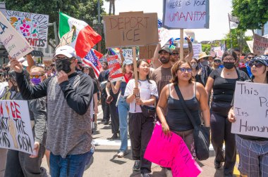 Los Angeles, Kaliforniya, ABD, 14 Temmuz 2025, Hükümetin politikalarını protesto eden ve demokrasi ve göçmen haklarını destekleyen protestocular ellerinde sloganlar tutuyorlar..