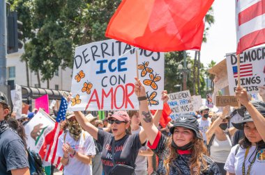 Los Angeles, Kaliforniya, ABD, 14 Temmuz 2025, Hükümetin politikalarını protesto eden ve demokrasi ve göçmen haklarını destekleyen protestocular ellerinde sloganlar tutuyorlar..