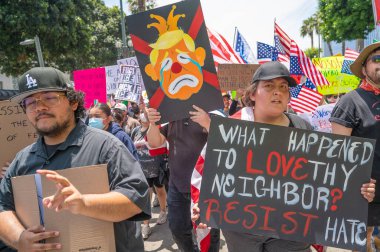 Los Angeles, Kaliforniya, ABD, 14 Temmuz 2025, Hükümetin politikalarını protesto eden ve demokrasi ve göçmen haklarını destekleyen protestocular ellerinde sloganlar tutuyorlar..