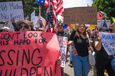 Los Angeles, Kaliforniya, ABD, 14 Temmuz 2025, Hükümetin politikalarını protesto eden ve demokrasi ve göçmen haklarını destekleyen protestocular ellerinde sloganlar tutuyorlar..