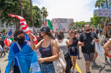 Los Angeles, Kaliforniya, ABD, 14 Temmuz 2025, Hükümetin politikalarını protesto eden ve demokrasi ve göçmen haklarını destekleyen protestocular ellerinde sloganlar tutuyorlar..