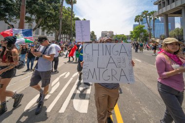 Los Angeles, Kaliforniya, ABD, 14 Temmuz 2025, Hükümetin politikalarını protesto eden ve demokrasi ve göçmen haklarını destekleyen protestocular ellerinde sloganlar tutuyorlar..