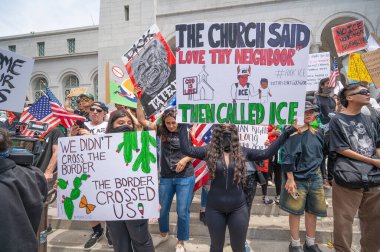 Los Angeles, Kaliforniya, ABD, 14 Temmuz 2025, Hükümetin politikalarını protesto eden ve demokrasi ve göçmen haklarını destekleyen protestocular ellerinde sloganlar tutuyorlar..