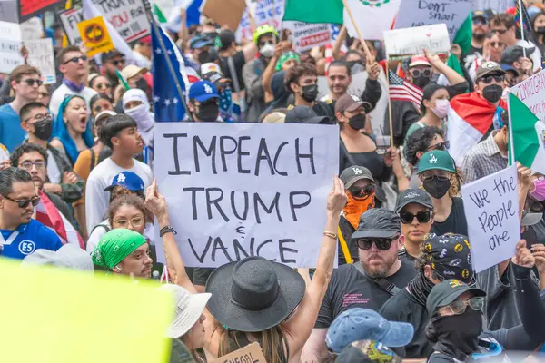 Los Angeles, Kaliforniya, ABD, 14 Temmuz 2025, Hükümetin politikalarını protesto eden ve demokrasi ve göçmen haklarını destekleyen protestocular ellerinde sloganlar tutuyorlar..