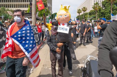 Los Angeles, California, USA, July 14, 2025, Protester carrying a doll during the No Kings protest against government policies and supporting democracy and immigrant rights