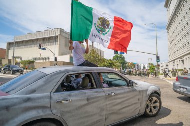 Los Angeles, California, USA, July 14, 2025, Protester in car holding a flag during the No Kings protest against government policies