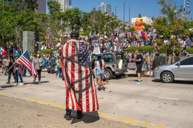 Los Angeles, Kaliforniya, ABD, 14 Temmuz 2025, Protestocu, Amerikan bayrağına anarşist sardı. Krallar Hükümetin politikalarını protesto ederken ve demokrasi ve göçmen haklarını desteklerken bir sembol.