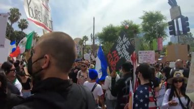 Los Angeles, Kaliforniya, ABD, 14 Temmuz 2025, Hükümetin politikalarını protesto eden ve demokrasi ve göçmen haklarını destekleyen protestocular ellerinde sloganlar tutuyorlar..