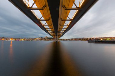 Yaz gecesi Yeni Haliç Metro Köprüsü İstanbul, Türkiye 'de mavi gökyüzü ve kent ışıkları