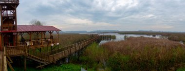 Göldeki iskele. Gökyüzü ve bulutların yansıması. Efteni Gölü, Türkiye.