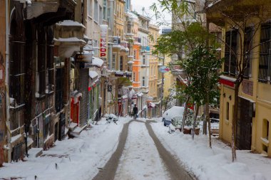 İstanbul 'da kış. Dar bir sokaktan tarihi Galata Kulesi manzarası ve karlı hava.