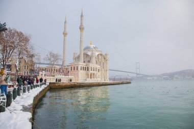 Ortakoy, İstanbul, Türkiye 'de karlı bir gün. Ortakoy Camii ve Boğaz Köprüsü Görünümü.