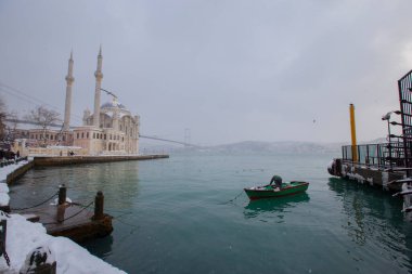 Ortakoy, İstanbul, Türkiye 'de karlı bir gün. Ortakoy Camii ve Boğaz Köprüsü Görünümü.