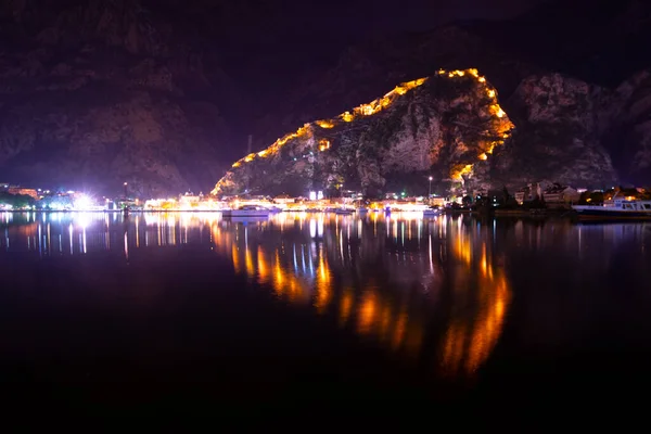 stock image Old Fortress Walls of Kotor, Motenegro Lit Up at Night and Reflecting on the Bay of Kotor