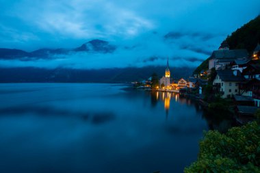 Avusturya Alplerinde Hallstattersee Gölü 'nde yansıyan ünlü Hallstatt göl kasabasının manzaralı panoramik manzarası. Yazın güneşli bir günde, Avusturya' nın Salzkammergut bölgesinde.