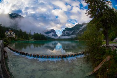 Toblacher Gölü (Lago di Dobbiaco) ve Dolomite dağları üzerinde panoramik manzara sisli bir sabah, Dolomitler, Güney Tyrol, İtalya 'nın geniş açılı renklerinde, sonbahar mevsiminde yakınlarda zirveler yapar.