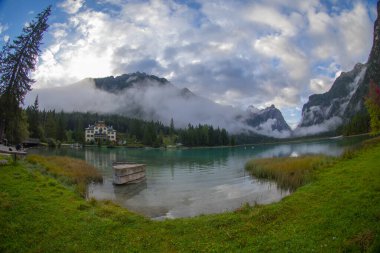 Toblacher Gölü (Lago di Dobbiaco) ve Dolomite dağları üzerinde panoramik manzara sisli bir sabah, Dolomitler, Güney Tyrol, İtalya 'nın geniş açılı renklerinde, sonbahar mevsiminde yakınlarda zirveler yapar.