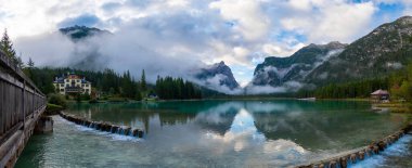 Toblacher Gölü (Lago di Dobbiaco) ve Dolomite dağları üzerinde panoramik manzara sisli bir sabah, Dolomitler, Güney Tyrol, İtalya 'nın geniş açılı renklerinde, sonbahar mevsiminde yakınlarda zirveler yapar.